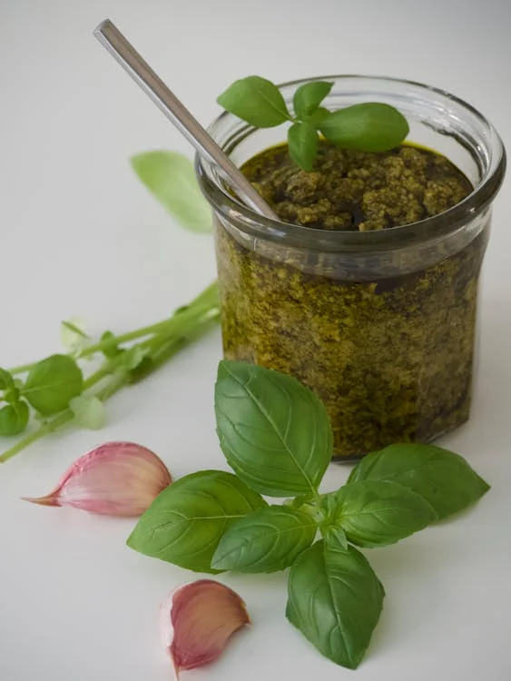 Petit pot en verre avec du pesto à l'intérieur